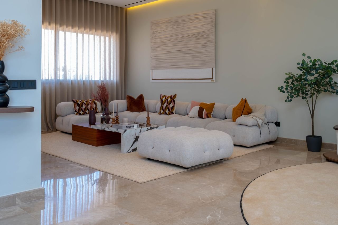 services-03 Stylish living room featuring a modern sofa, decorative cushions, and a lush plant, creating a cozy atmosphere.